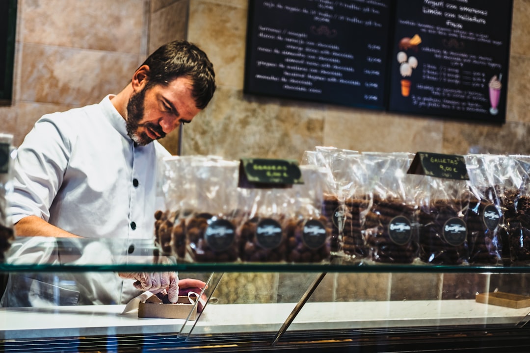 Hand-finished pralines in glass cases at an artisan chocolate shop in Bruges Belgium