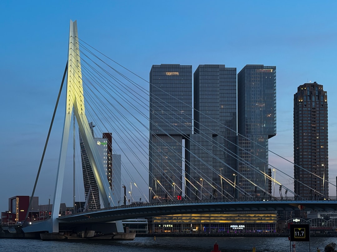 Erasmus Bridge and Kop van Zuid skyline at dusk in Rotterdam Netherlands