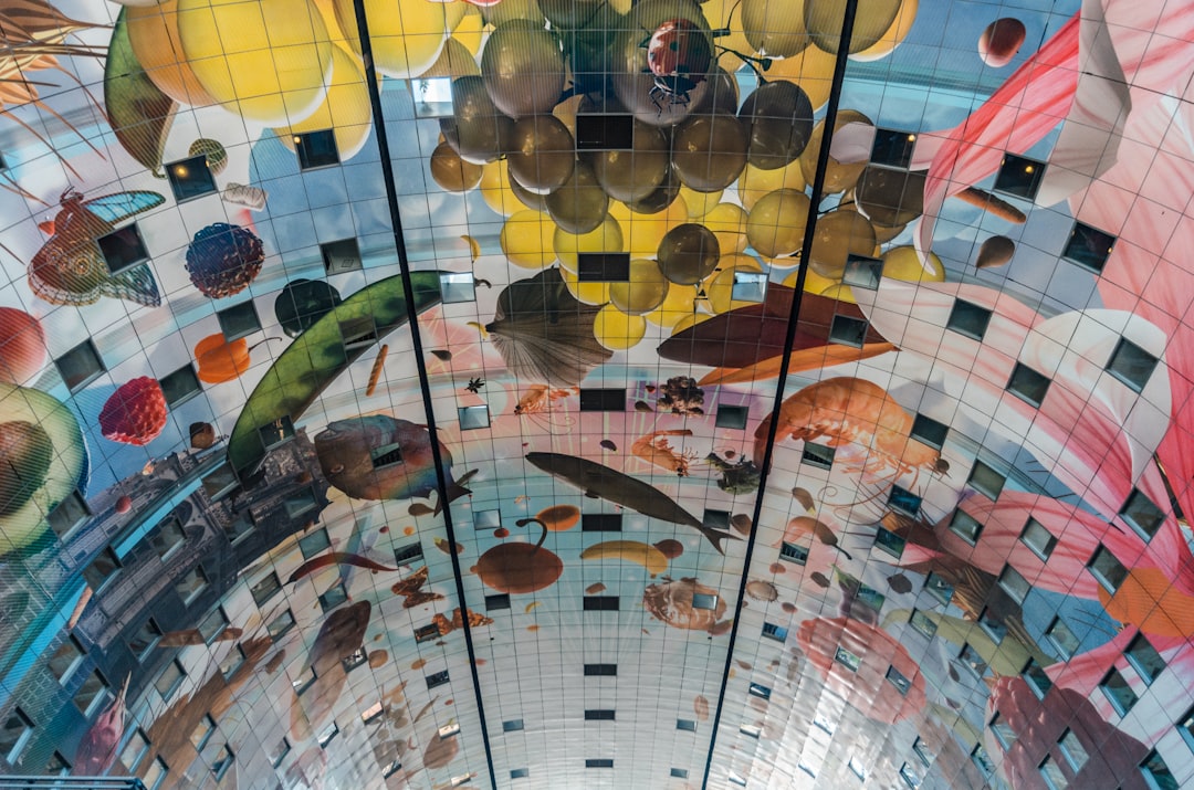 Inside Rotterdam Markthal with Horn of Plenty ceiling mural and market stalls