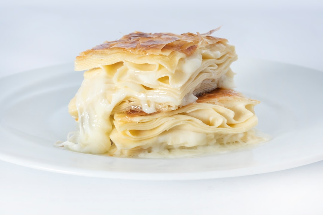 Bougatsa cream pastry being sliced at a traditional bakery counter in Thessaloniki Greece