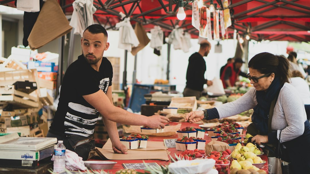 Vendors and shoppers inside Les Halles de Lyon Paul Bocuse food market with cheese and charcuterie displays