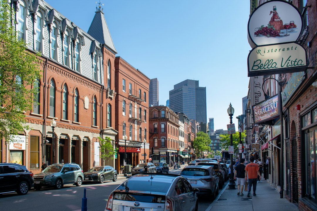 Brick storefronts and restaurant signs along a street in Boston's North End