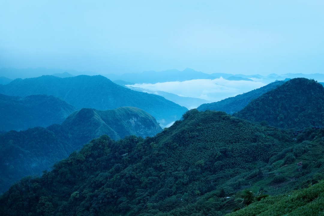 Green mountains under a pale sky in daytime