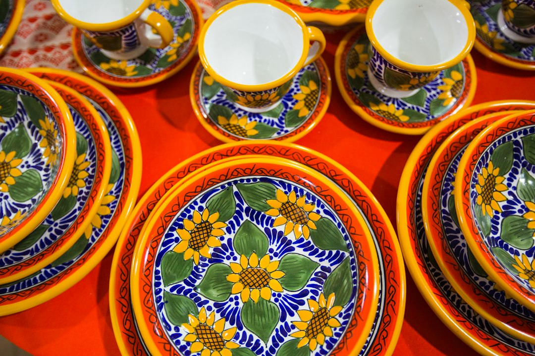 A floral ceramic bowl in white, blue and red on a red table
