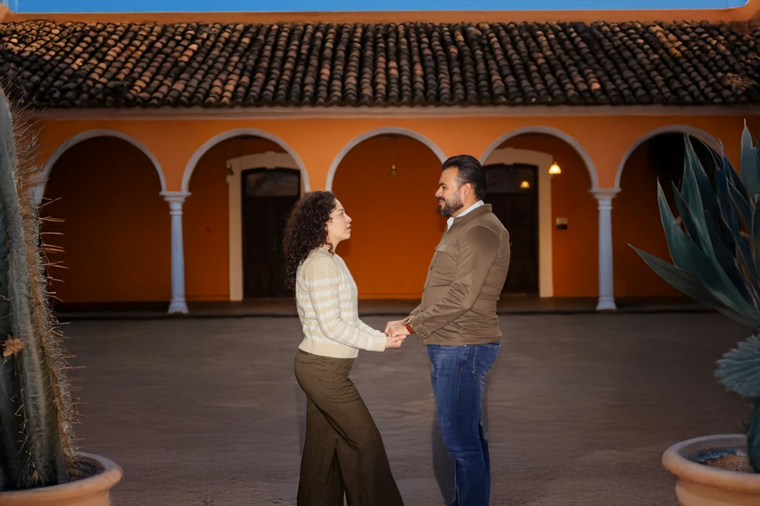 A man and a woman standing in front of a building