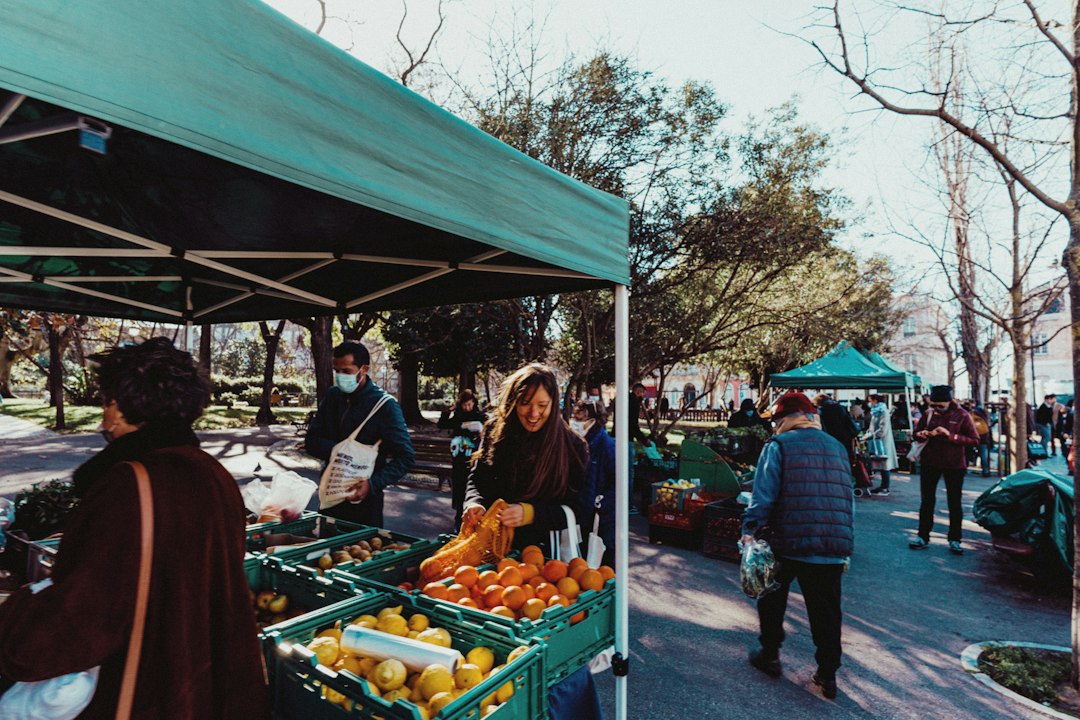 People gathered around a fruit stand at an outdoor market