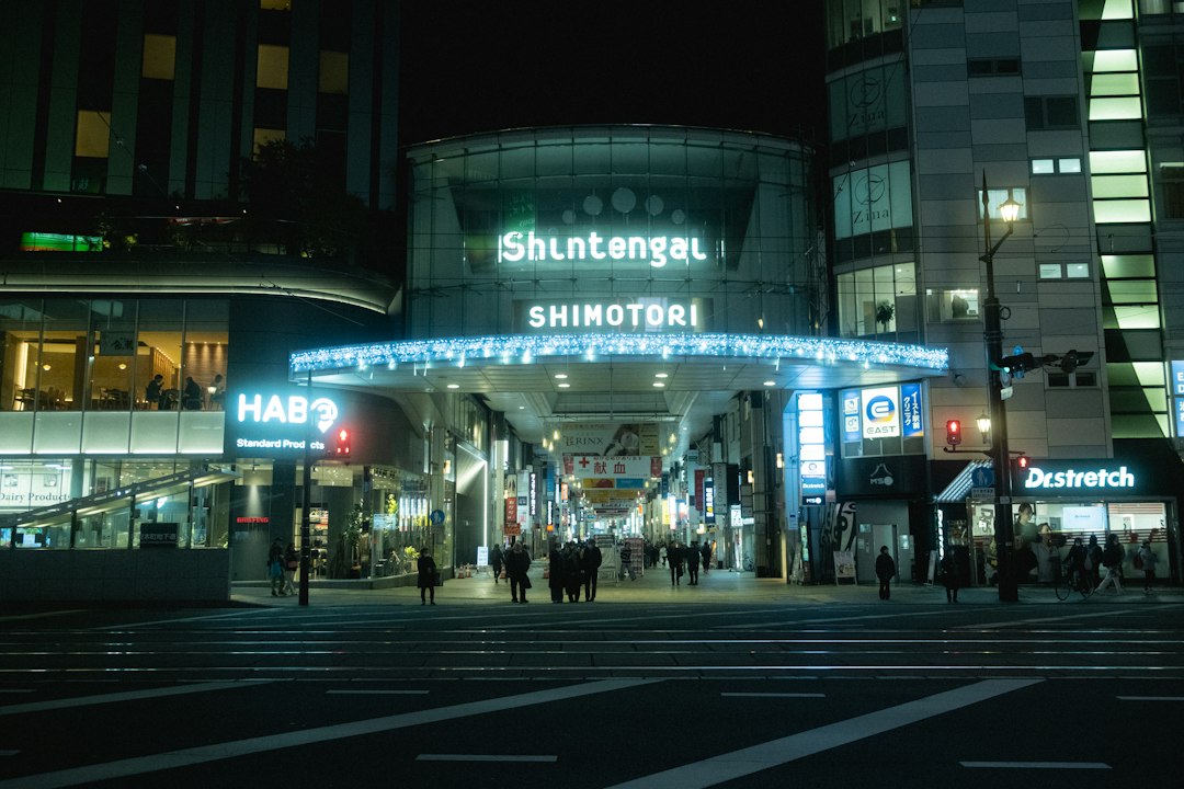 A shopping street at night with glowing shop signs in Kumamoto, Japan