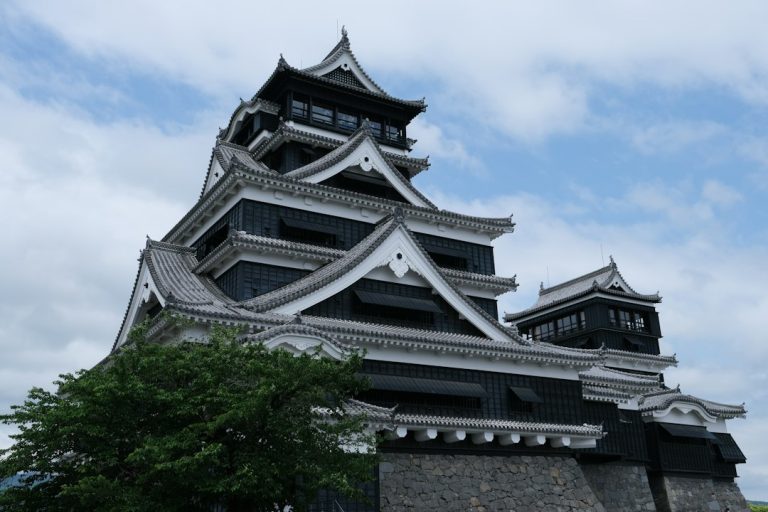 A majestic japanese castle stands tall against the sky in Kumamoto, Japan