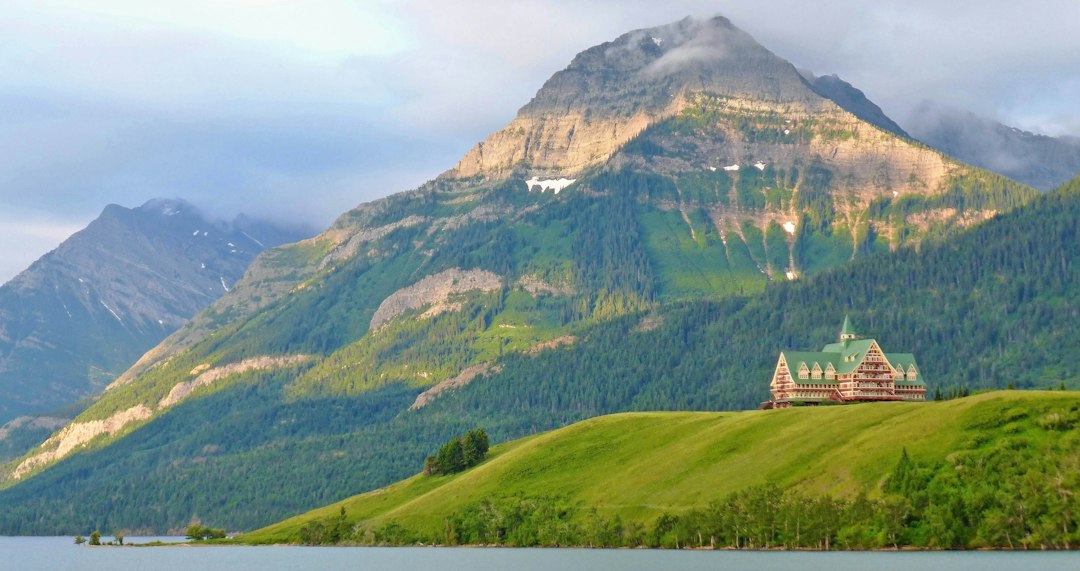 A hotel on a hill overlooking a body of water in Waterton, Alberta