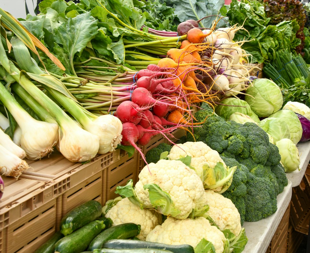 Fresh cauliflower, broccoli, radishes and onions on a market stall