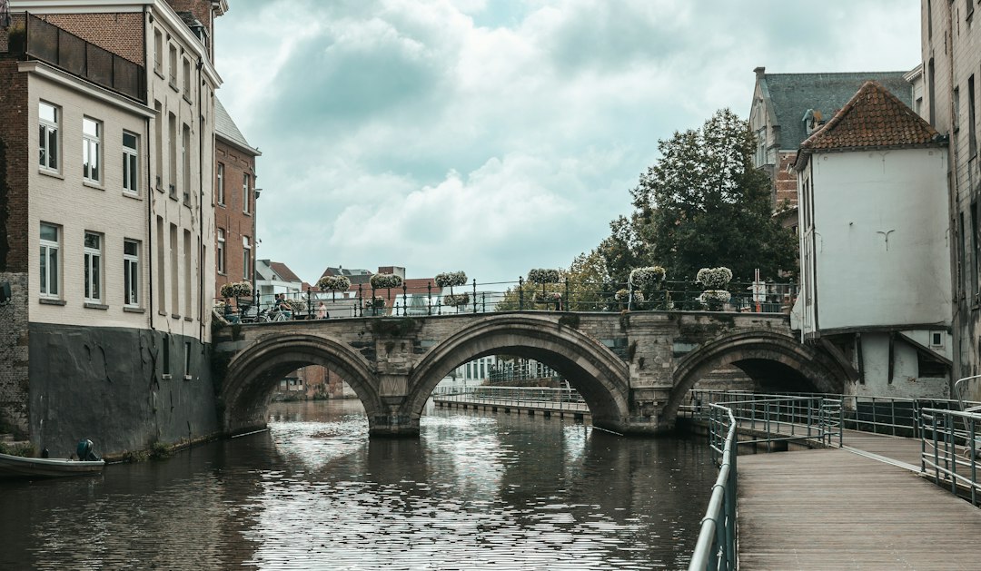 Stone bridge and wooden riverside boardwalk along the Dijle in Mechelen, Belgium