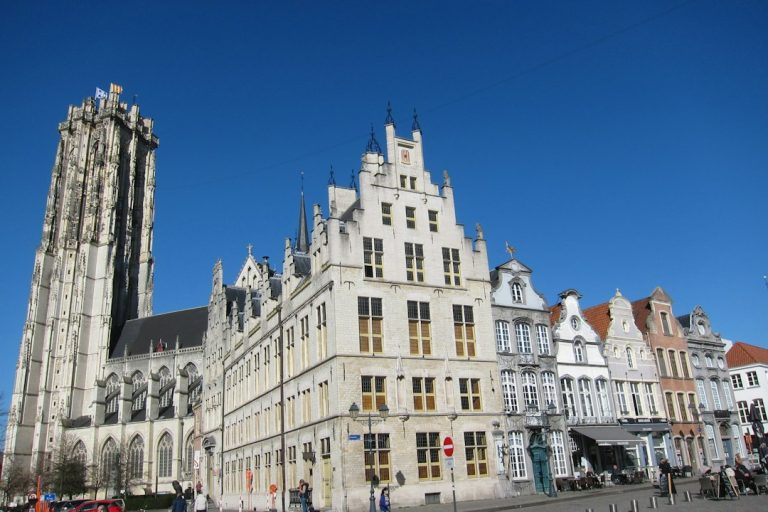 St. Rumbold's Tower rising above the gabled facades of the Grote Markt in Mechelen, Belgium