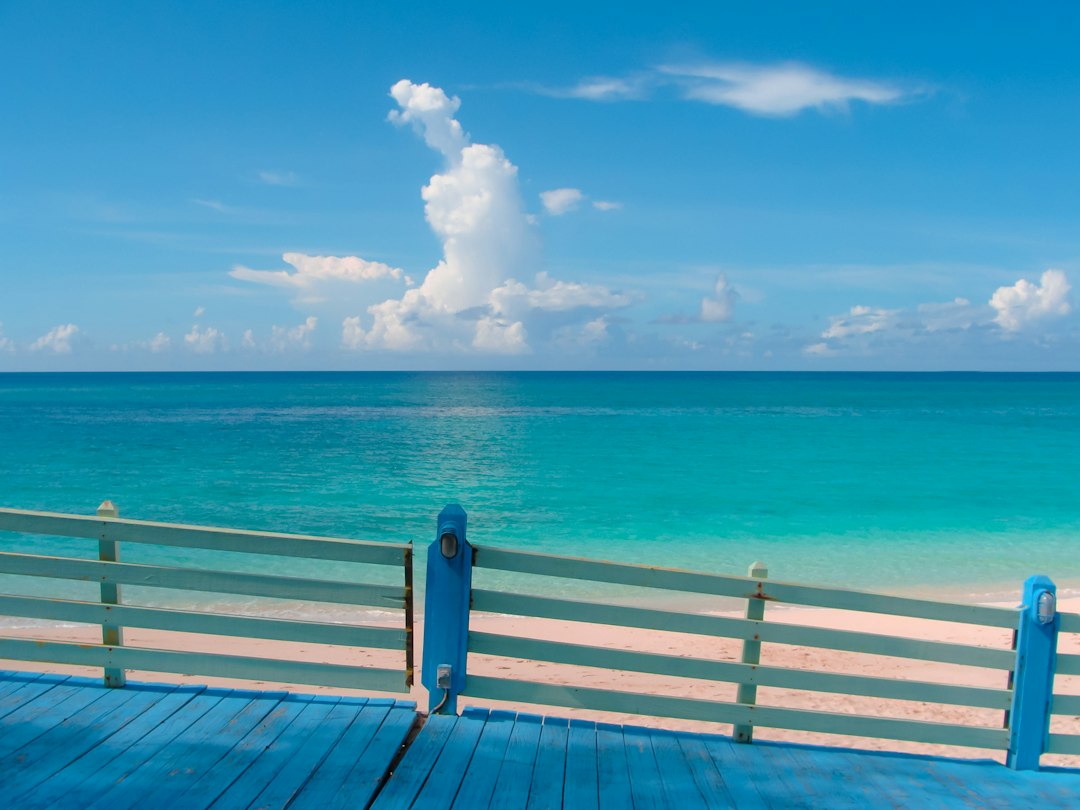 Turquoise Caribbean water seen from a pastel railing in Nassau, The Bahamas