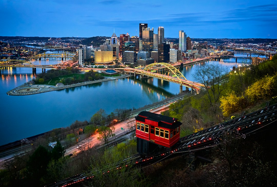 Aerial photo of bridge and buildings under blue sky in Pittsburgh
