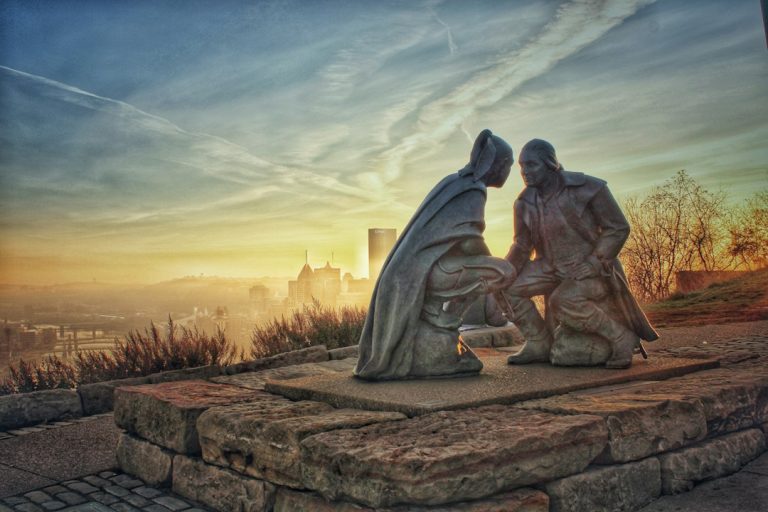 Man sitting on rock formation during sunset in Pittsburgh