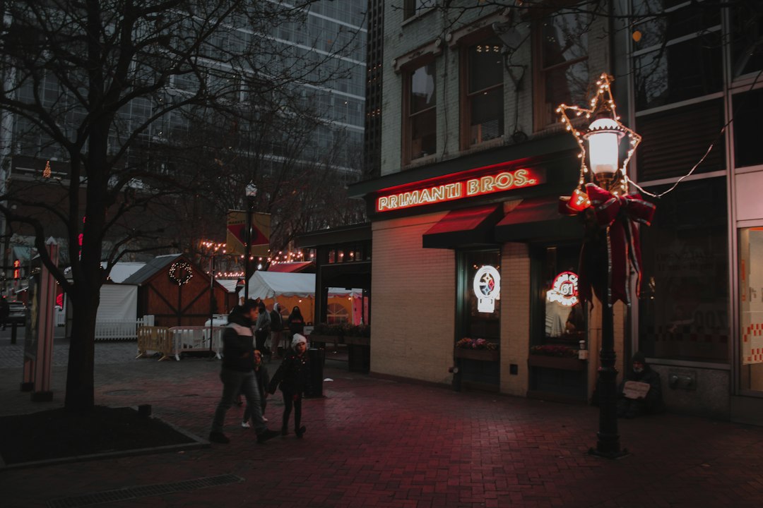 A group of people walking down a street at night in Pittsburgh