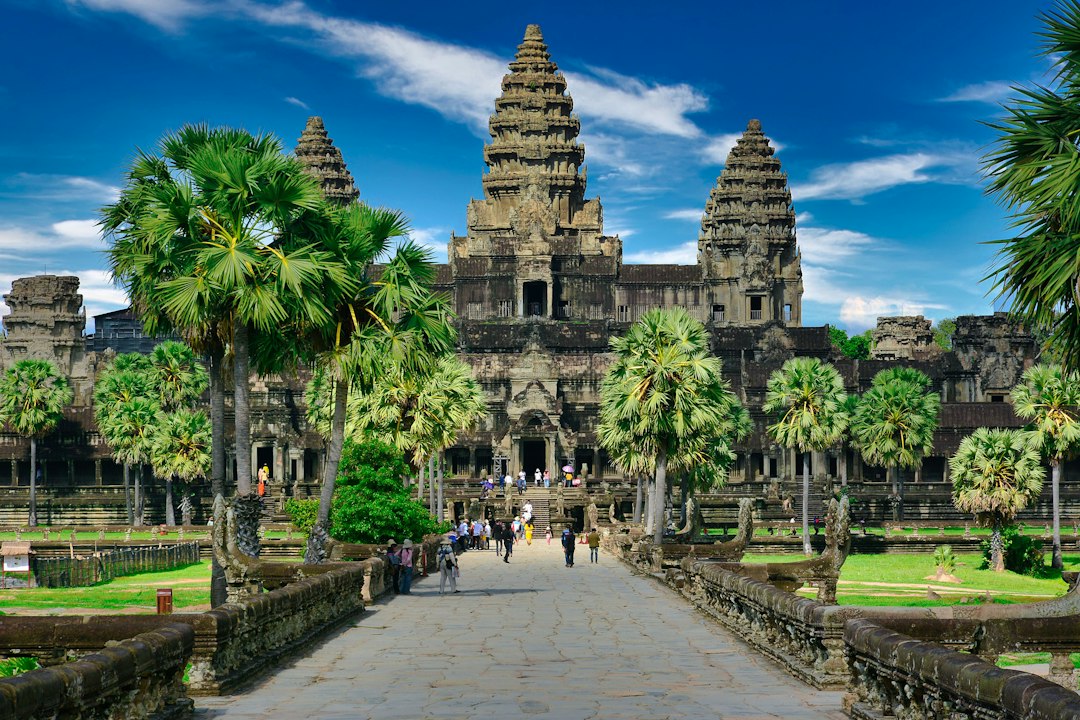 People walking along a stone path toward the Angkor Wat temple in Cambodia in Siem Reap, Cambodia