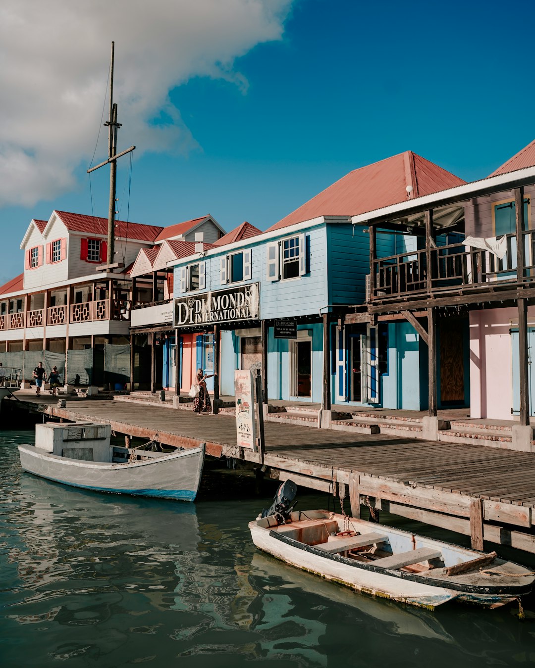 Pastel wooden waterfront buildings beside a small boat in St. John's, Antigua